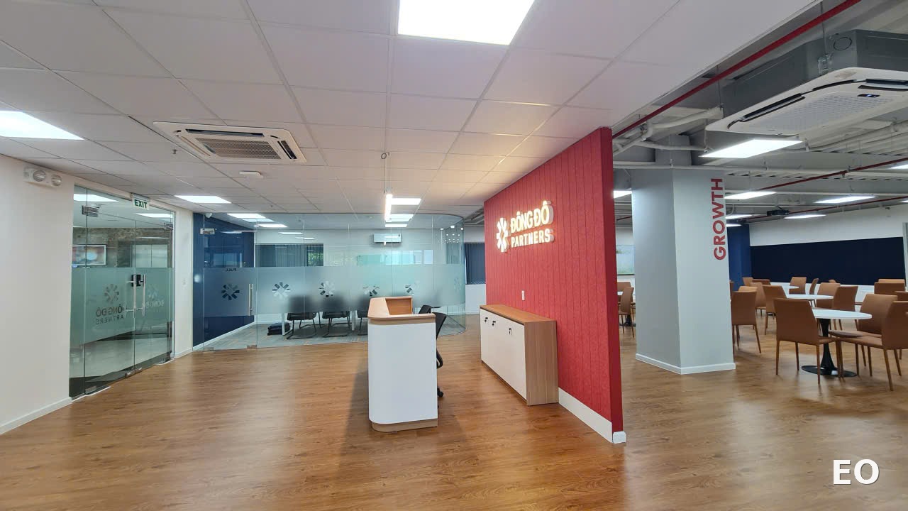 Sảnh lễ tân Đông Đô Partners với vách backlit thương hiệu đỏ và cột GROWTH tại khu vực đa năng